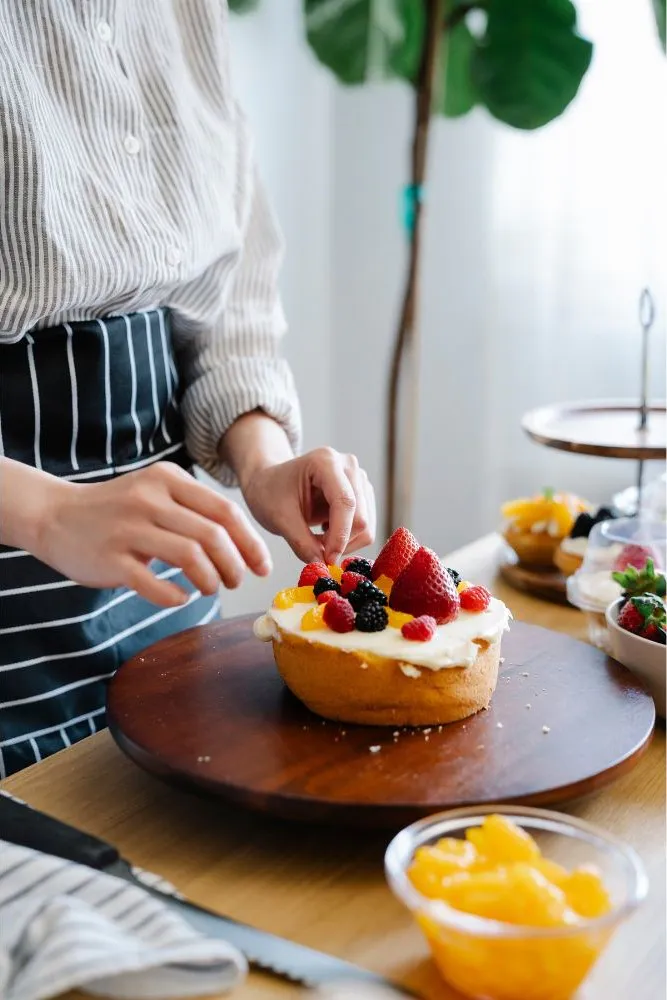 Decorating fresh fruit cream cake at Dragon Bay Bakery, a Chinese Bakery in Brooklyn